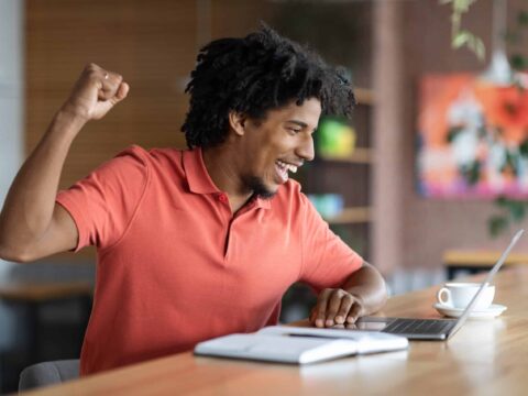 Man Looking At Laptop Screen And Celebrating Success.